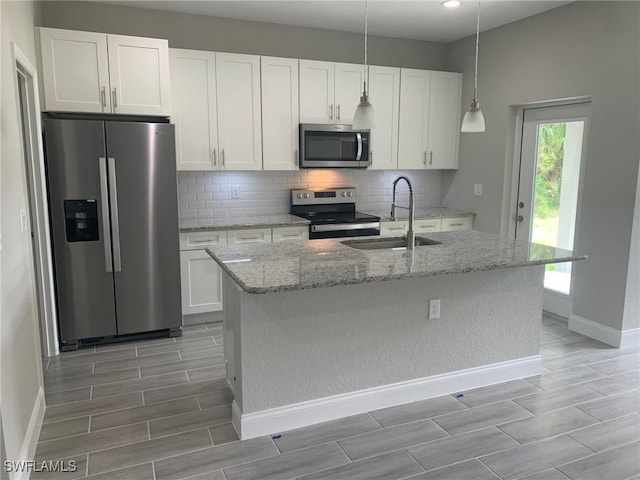 kitchen featuring backsplash, appliances with stainless steel finishes, white cabinets, and a sink