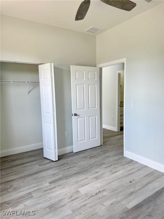 2001 Jeronimo Rd, Labelle, FL 33935 - unfurnished bedroom with baseboards, wood finished floors, a closet, and ceiling fan