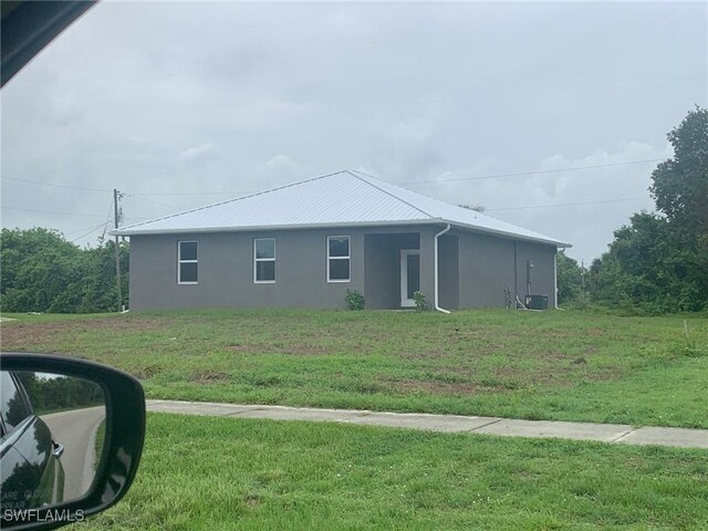 2001 Jeronimo Rd, Labelle, FL 33935 - view of side of home with stucco siding and a lawn