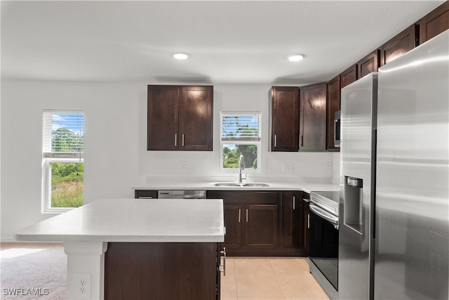 kitchen featuring light tile patterned flooring, a kitchen island, stainless steel appliances, dark brown cabinets, and sink