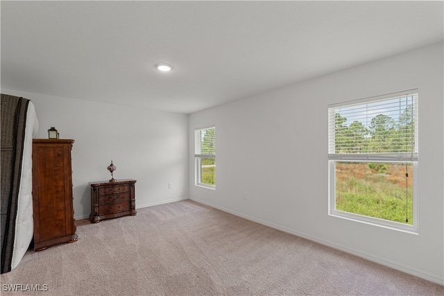 unfurnished room featuring light carpet