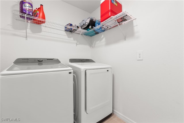 washroom with light tile patterned flooring and washing machine and clothes dryer