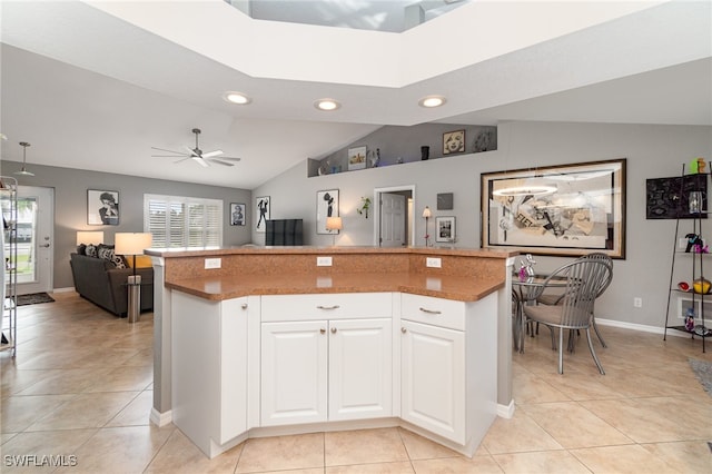 kitchen with lofted ceiling, ceiling fan, plenty of natural light, and white cabinetry