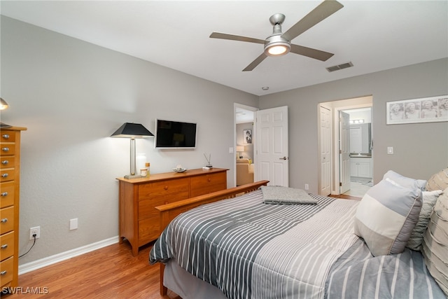 bedroom featuring light hardwood / wood-style flooring, ensuite bathroom, and ceiling fan