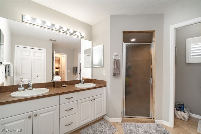 bathroom with vanity, tile patterned flooring, and a shower with door