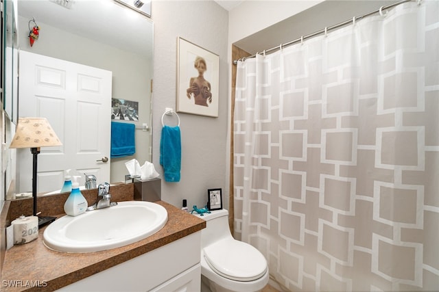 bathroom with walk in shower, toilet, and vanity