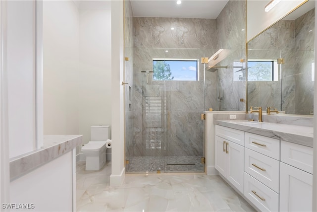 bathroom featuring a wealth of natural light, vanity, toilet, and a shower with shower door