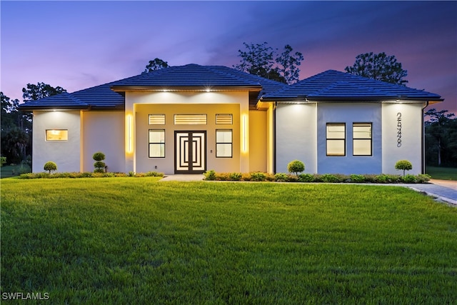 view of front of home featuring french doors and a yard