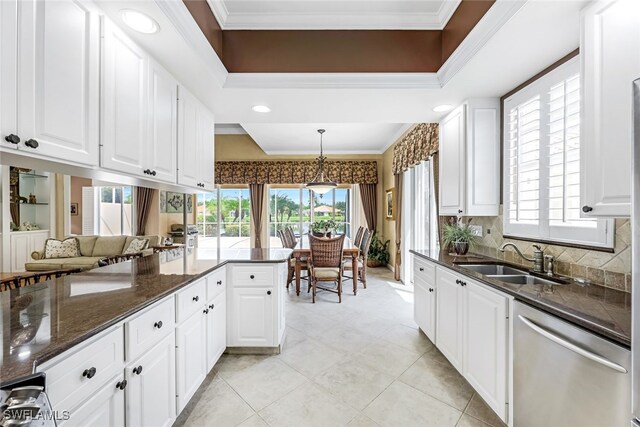 kitchen with sink, white cabinetry, crown molding, stainless steel dishwasher, and pendant lighting