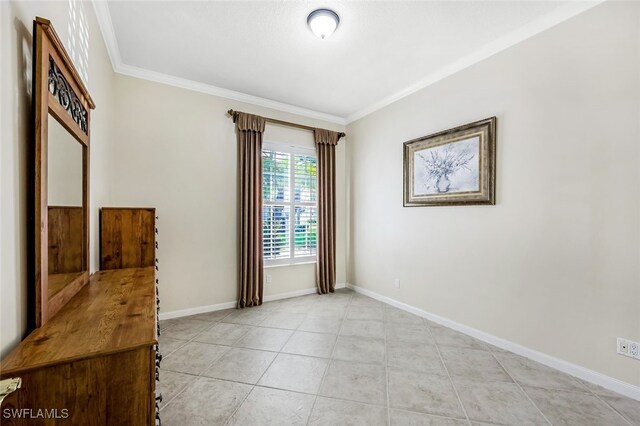 spare room with ornamental molding and light tile patterned flooring