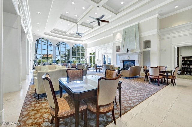 tiled dining room featuring ceiling fan, a towering ceiling, ornamental molding, and coffered ceiling