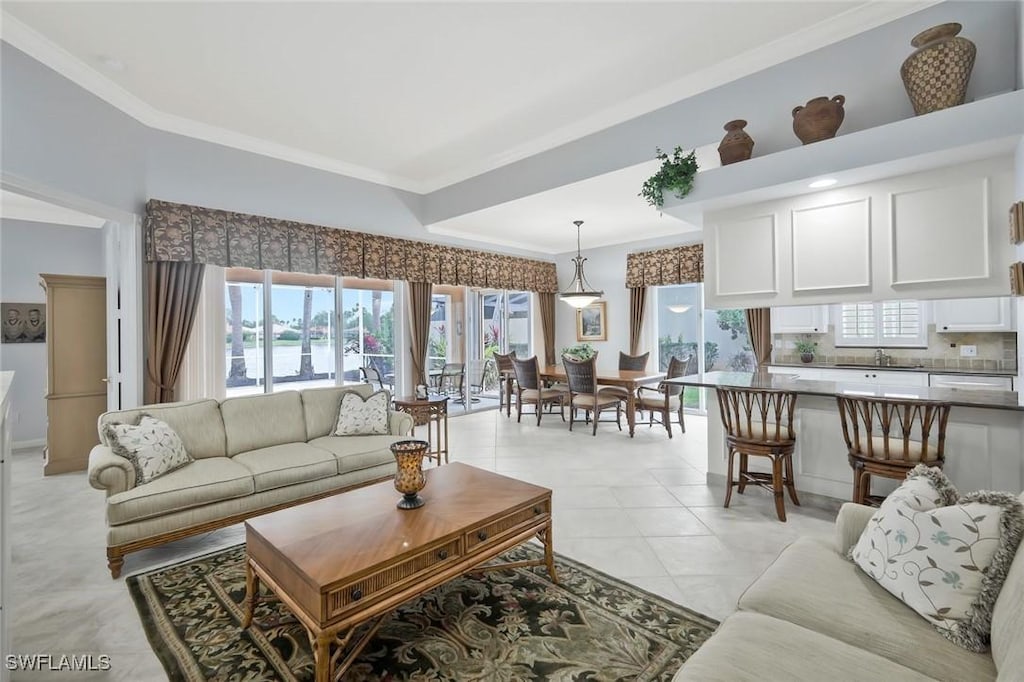 5449 Freeport Ln, Naples, FL 34119 - living room featuring ornamental molding and plenty of natural light
