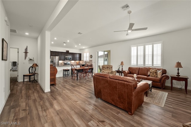 living room with wood-type flooring and ceiling fan