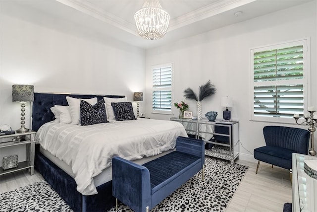 bedroom featuring light hardwood / wood-style floors, ornamental molding, and a chandelier