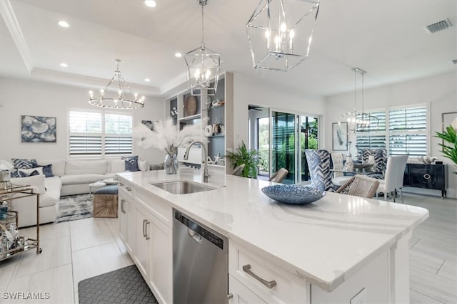 kitchen featuring stainless steel dishwasher, white cabinets, sink, and a kitchen island with sink