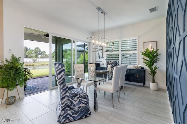 dining area featuring light tile patterned floors and ceiling fan with notable chandelier