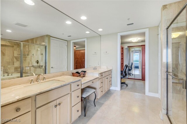 bathroom with a shower with door and vanity