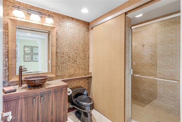 bathroom with vanity, an enclosed shower, tile walls, and tile patterned flooring