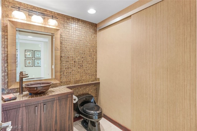 bathroom featuring vanity, toilet, tile patterned floors, and tile walls