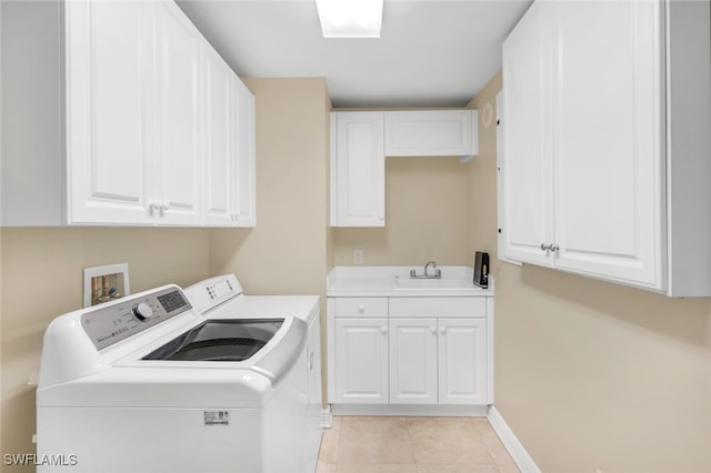 clothes washing area with cabinets, sink, washing machine and clothes dryer, and light tile patterned floors