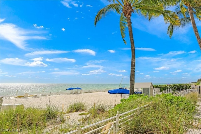 view of water feature with fence and a view of the beach