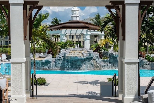 view of pool with a pergola, a patio, and pool water feature