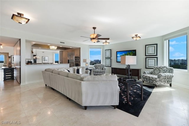 living area featuring visible vents, a healthy amount of sunlight, light tile patterned flooring, and ceiling fan