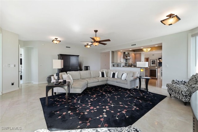 living room featuring visible vents, a ceiling fan, and wine cooler