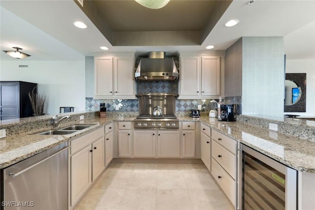kitchen with wall chimney exhaust hood, dishwasher, a peninsula, and beverage cooler