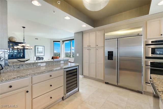 kitchen featuring beverage cooler, recessed lighting, appliances with stainless steel finishes, pendant lighting, and light tile patterned flooring