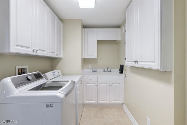 laundry room featuring a sink, baseboards, light tile patterned flooring, separate washer and dryer, and cabinet space