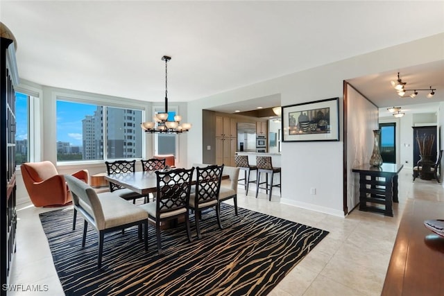 dining space featuring a chandelier and baseboards