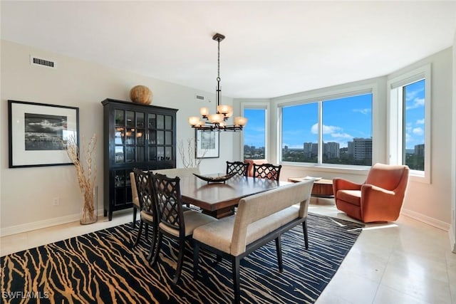 tiled dining area featuring an inviting chandelier, visible vents, a healthy amount of sunlight, and baseboards