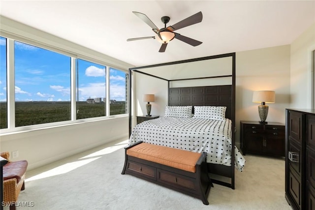 bedroom featuring baseboards, a ceiling fan, and light carpet