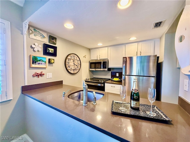 kitchen featuring white cabinets, appliances with stainless steel finishes, and sink