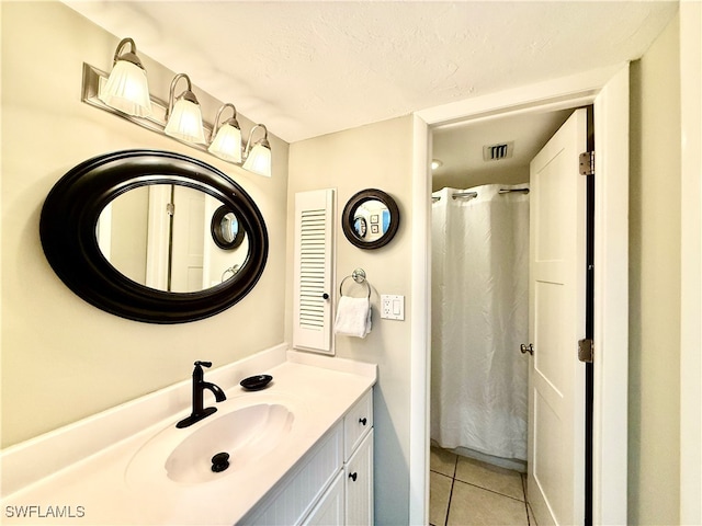 bathroom featuring tile patterned flooring, vanity, a shower with shower curtain, and a textured ceiling