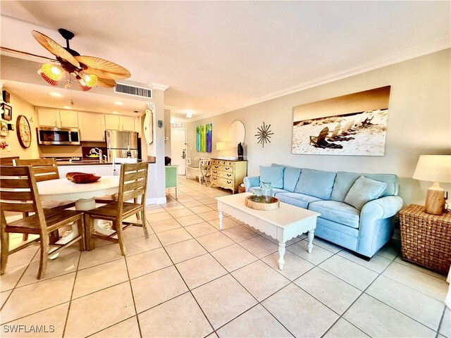 tiled living room with ornamental molding and ceiling fan