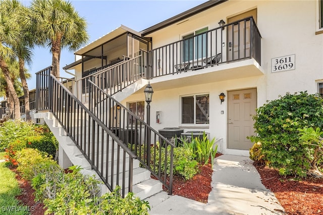 view of front of home featuring a balcony and cooling unit