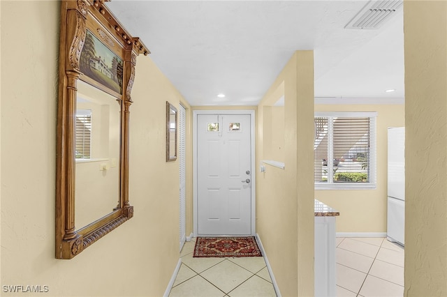 doorway to outside with light tile patterned floors