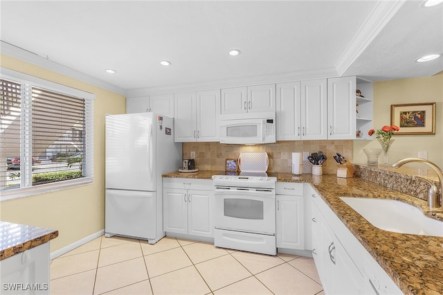 kitchen with sink, white appliances, white cabinetry, and decorative backsplash