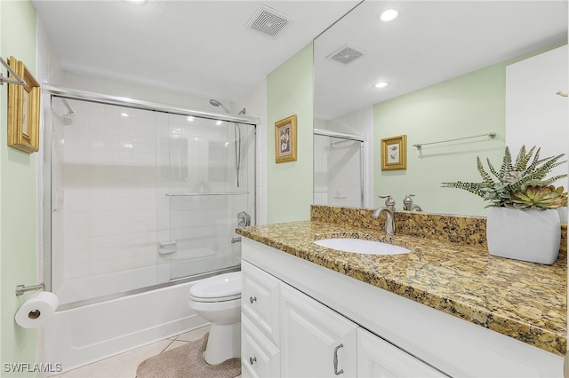 full bathroom with combined bath / shower with glass door, vanity, toilet, and tile patterned floors