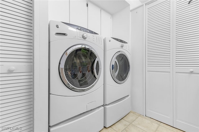 laundry area with light tile patterned floors and independent washer and dryer