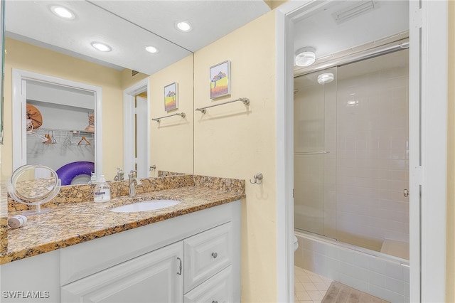 bathroom with combined bath / shower with glass door and vanity