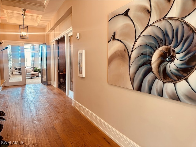 hall featuring ornamental molding, french doors, coffered ceiling, and hardwood / wood-style flooring