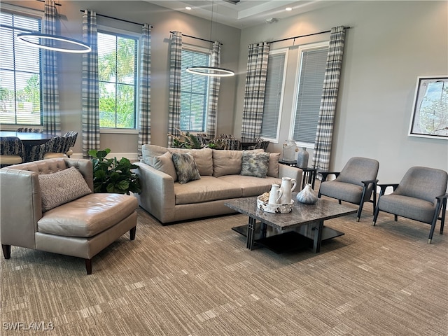 carpeted living room featuring an inviting chandelier