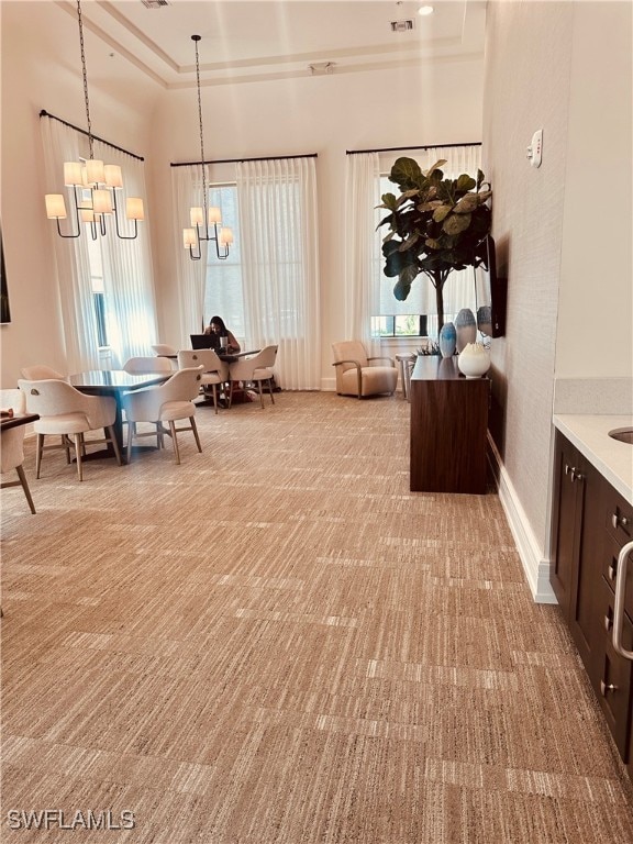 sitting room with an inviting chandelier and light colored carpet