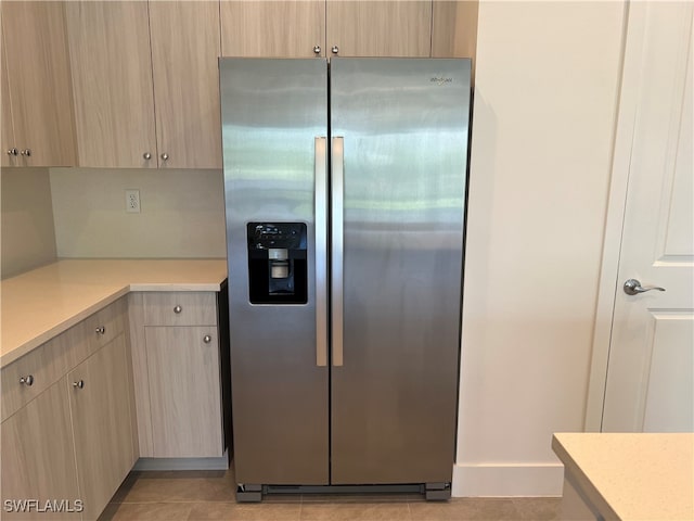 kitchen with light tile patterned floors, light brown cabinets, and stainless steel fridge with ice dispenser