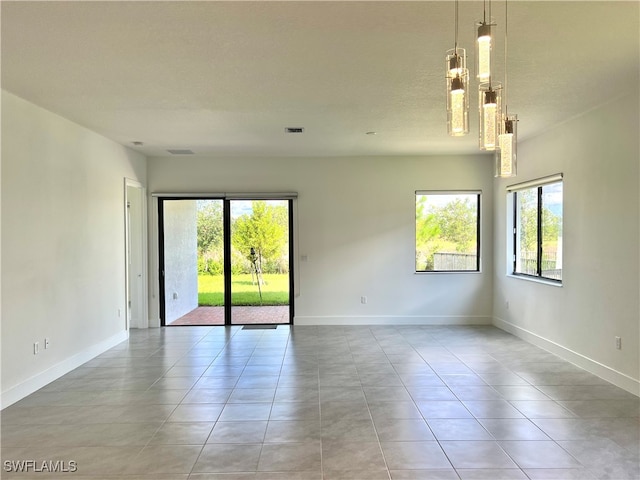 tiled empty room featuring a textured ceiling