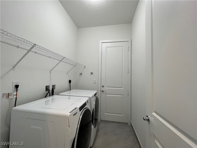 laundry area with a textured ceiling and washer and clothes dryer