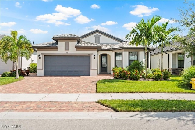 mediterranean / spanish house with a garage and a front lawn